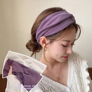 Detail of soft purple and white knitted headband featuring a stylish knotted twist design