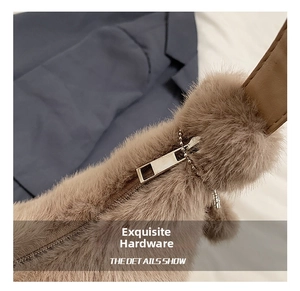 Detail of golden metal zipper and plush faux fur texture on brown shoulder bag