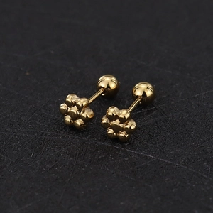 Macro shot of gold floral screw-back stud earrings with polished six-petal design
