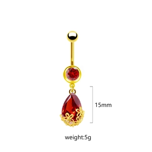 Dettaglio del piercing all'ombelico con goccia rossa da 15mm, fiore d'oro e peso 5g