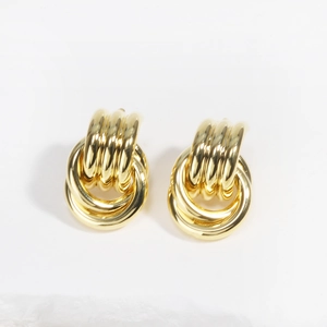 Detail of gold interlocking metal hoop earrings with elegant multi-layer circle design