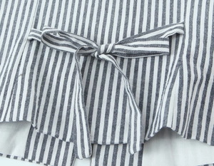 Détail du tissu à rayures bleues et blanches avec un laçage au dos du haut sans manches