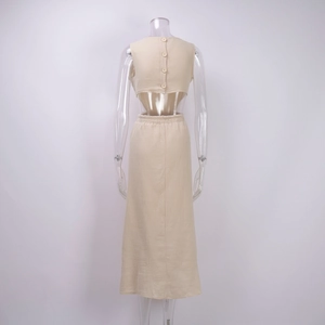 Detail view of the beige back button closure and elastic waist on a textured two-piece dress