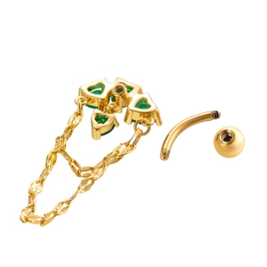 Piercing ombelico dorato con zirconi verdi a cuore e catenine pendenti su fondo bianco