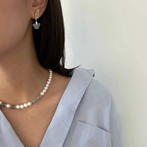 Close-up of elegant glacier blue cat eye beads and heart pendant necklace on model