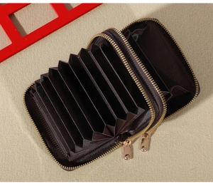 Detail view of double zipper accordion card wallet in dark brown with gold hardware