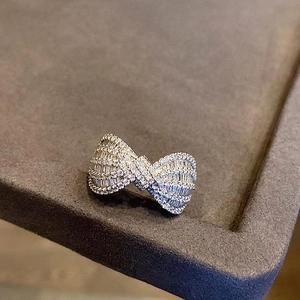 Detail of elegant silver bow ring with micro-pave cubic zirconia on gray jewelry tray
