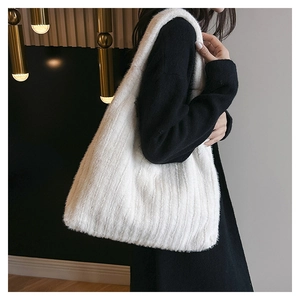 Close-up of white plush tote bag showing soft faux fur texture and large shoulder strap