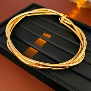 Gros plan d'un collier serpent multicouche doré avec finition métallique brillante