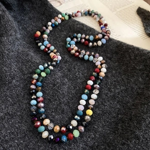 Detailed macro view of colorful faceted crystal beads on grey textured knit fabric