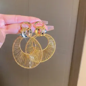 Exaggerated gold hollow round hoop earrings with intricate metallic woven texture for women