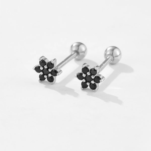 Detail of silver flower stud earrings with a black gemstone and ball screw back closure