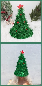 Close-up of green tinsel Christmas tree hat with red pom-poms and star decoration