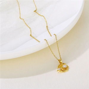 Golden sun crescent moon and star pendant necklace with cubic zirconia on white dish