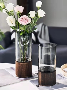 Detail of Nordic glass vase with wooden base featuring pink lisianthus flowers
