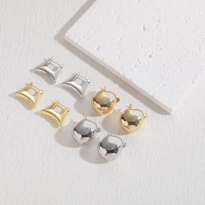 Minimalist geometric 14K gold and silver plated earrings on white aesthetic block