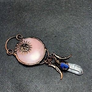 Detailed retro bronze wire-wrapped sun and moon pendant with pink quartz and blue crystal