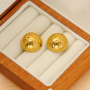 Hammered 18K gold-plated stainless steel stud earrings in a luxury jewelry box display