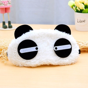 Dettaglio della morbida maschera per dormire a forma di panda su sfondo in legno