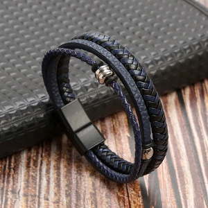 Detail of multi-layer woven leather bracelet in blue and black with magnetic metal clasp