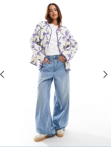 Quilted floral jacket with purple piping detail worn with casual denim jeans and sneakers