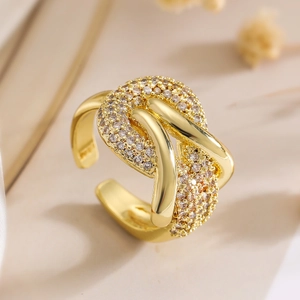 Close-up of golden irregular geometric ring with zircon pavé and twisted rope design
