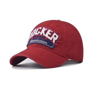 Detail of vintage Rocker embroidery patch on washed cotton baseball cap in burgundy