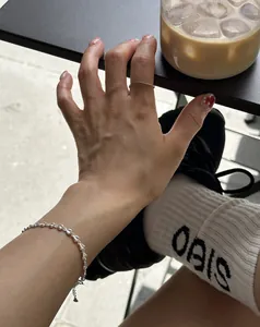 Close-up of a minimalist S925 sterling silver heart bracelet on a woman wrist
