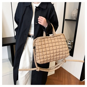 Close-up of khaki quilted puffer tote bag with adjustable shoulder strap and soft texture