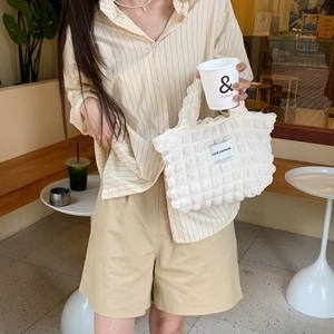 White bubble texture quilted handbag with LOVE SOZAKKA label in casual cafe setting