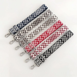 Detail of colorful woven shoulder straps with geometric patterns and silver metal buckles