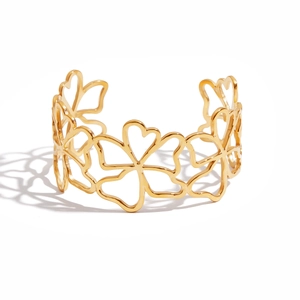 Detail shot of a minimalist 18K gold plated stainless steel open bangle with hollow flowers