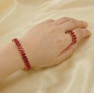 Detail of 18K gold-plated bangle and ring set with marquise-cut red zircon stones