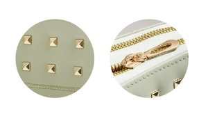 Détail d'un porte-monnaie vert clair avec rivets carrés dorés et fermeture éclair