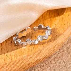 Silver hollow leaf open ring in stainless steel displayed on a wooden tray with silk