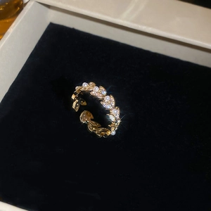 Macro shot of adjustable gold ring with wheat leaf patterns, zircons and pearls