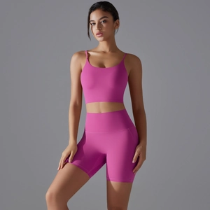 Dettaglio dei pantaloncini yoga rosa a vita alta e reggiseno sportivo con cuciture fini