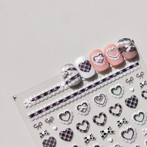 Detail of pink and black plaid nail stickers with lace hearts and bow-knot patterns