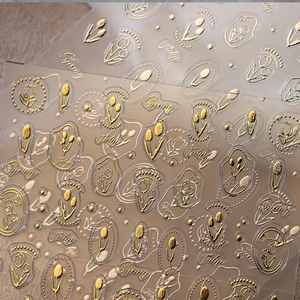 Macro view of 3D embossed gold tulip nail stickers with elegant Spring and Tulip patterns