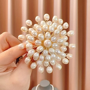 Detailed view of handmade freshwater pearl brooch with gold wire flower design