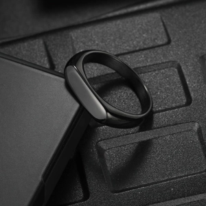 Macro shot of a minimalist black signet ring with high-gloss finish and smooth texture