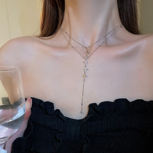 Close-up of double-layer silver Y-necklace with star pendants on a fashion model
