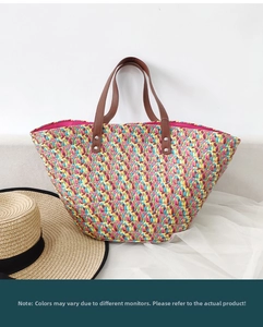 Detailed macro shot of a colorful woven straw tote bag with brown leather handles