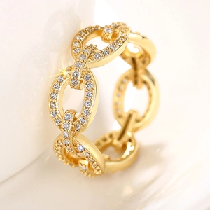 Macro detail of gold-tone Cuban link ring featuring pavé set white crystals