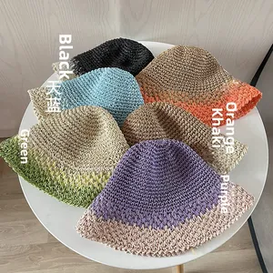 Dettaglio di cappelli di paglia intrecciati a mano in nero, blu e tonalità arancio
