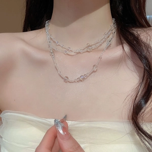 Detail of transparent glass multi-layer beaded necklace on model neck for elegant look