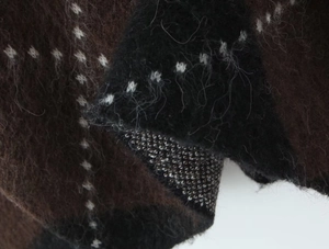 Close-up of knit mohair fabric texture with premium plaid pattern in brown and black