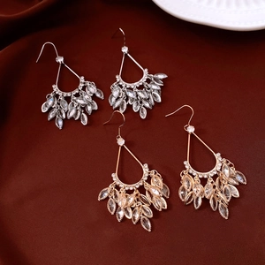 Detail of 18k gold and silver teardrop tassel earrings with zircons on red silk