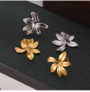 Detailed macro view of two-tone gold and silver flower stud earrings on leather