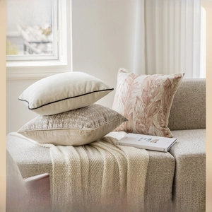 Detail of beige and brown textured cushion covers with botanical prints on a sofa